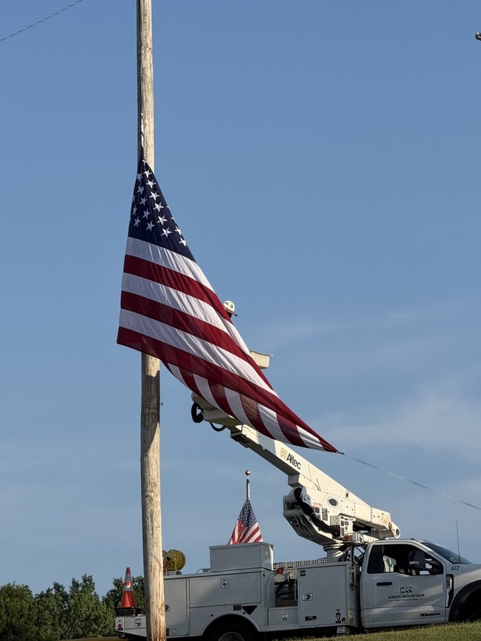 American flag raised on a bucket truck