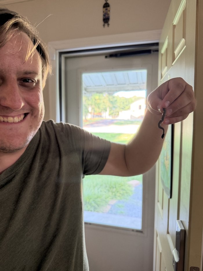John holding a small snake